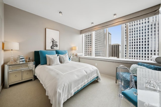 carpeted bedroom featuring baseboards and a city view