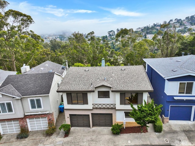 173 Warren Dr, San Francisco, CA 94131 - view of front of house featuring a garage, stucco siding, a shingled roof, driveway, and view of wooded area