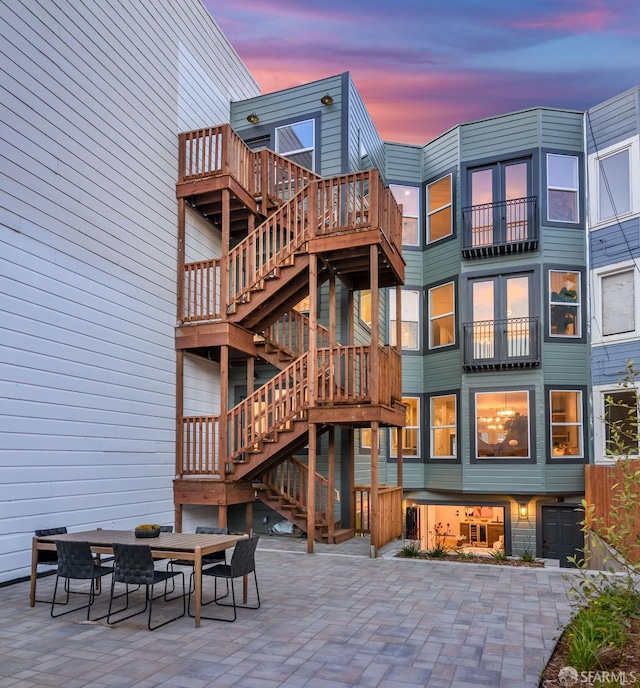 back house at dusk featuring a patio