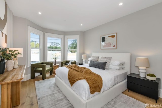 bedroom featuring multiple windows and light hardwood / wood-style flooring