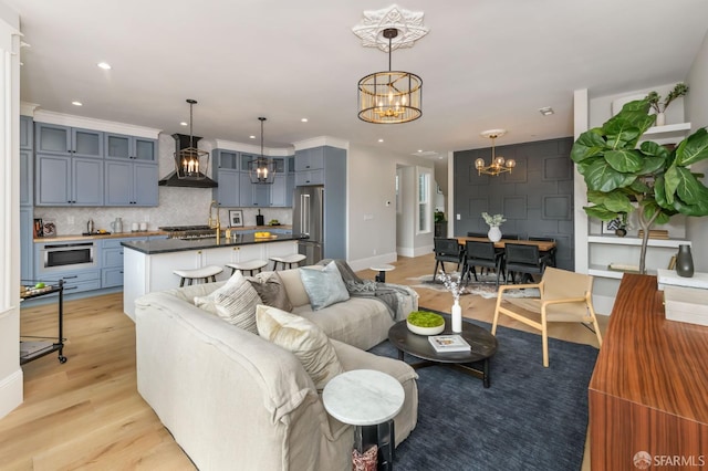 living room with a notable chandelier and light hardwood / wood-style floors