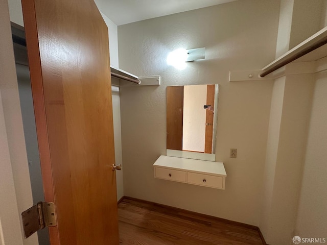 spacious closet with hardwood / wood-style flooring