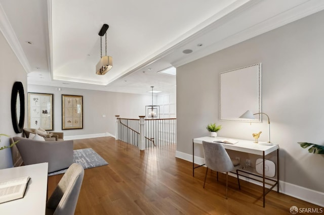 interior space featuring a tray ceiling, ornamental molding, and hardwood / wood-style flooring