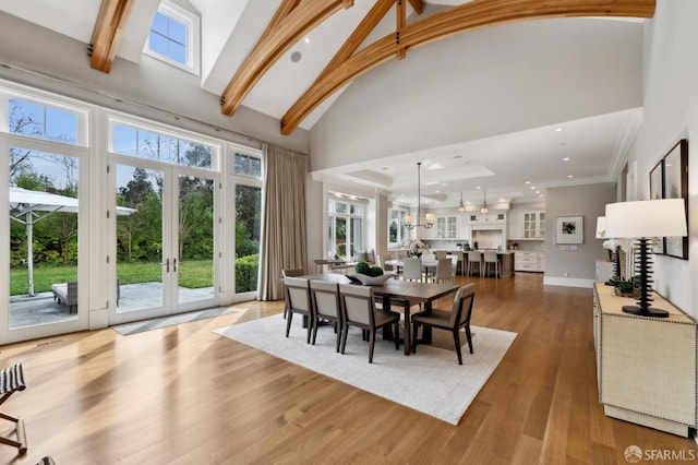 dining area with a wealth of natural light, dark wood-type flooring, high vaulted ceiling, and french doors