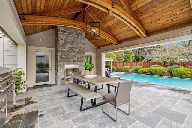 view of patio / terrace featuring a fenced in pool and an outdoor stone fireplace