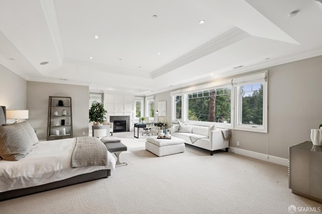 bedroom with a tray ceiling, crown molding, and light colored carpet