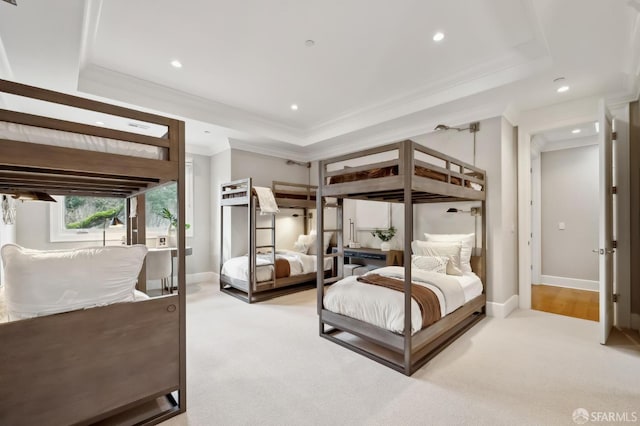 carpeted bedroom with crown molding and a tray ceiling