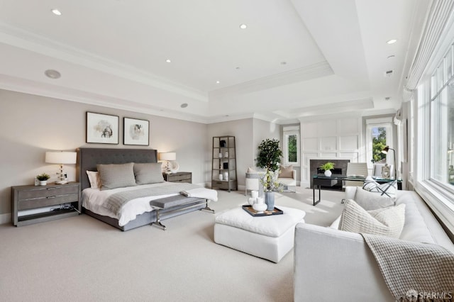 carpeted bedroom with a tray ceiling and crown molding