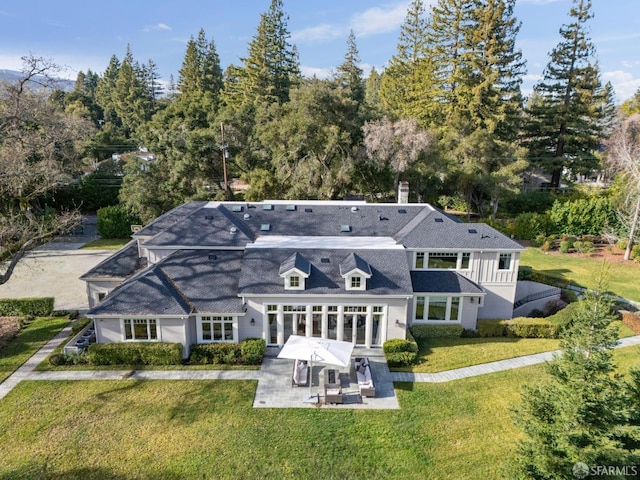 back of property featuring a lawn and a patio area