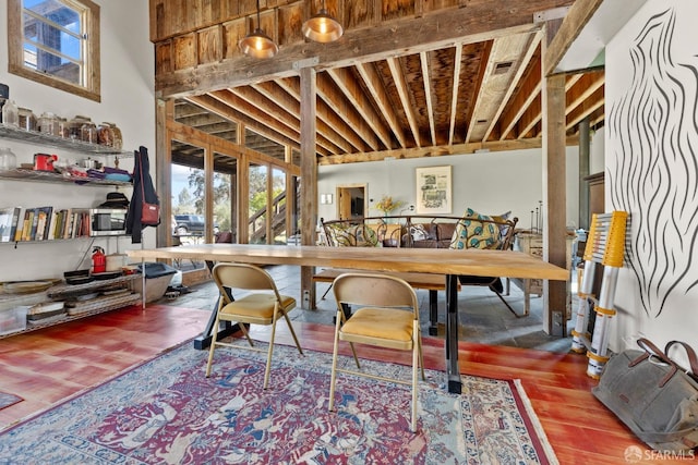 interior space with a high ceiling, wood-type flooring, beam ceiling, and french doors