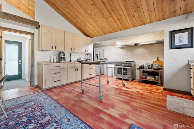 kitchen with wooden ceiling, stainless steel appliances, vaulted ceiling, wall chimney exhaust hood, and light brown cabinetry