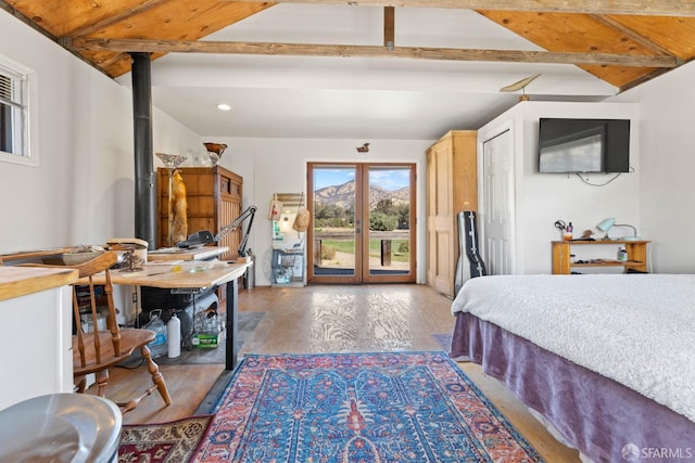 bedroom featuring lofted ceiling with beams, wood finished floors, a wood stove, access to exterior, and recessed lighting