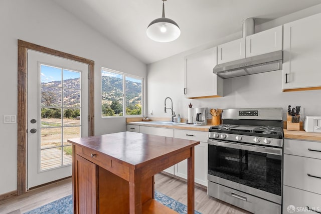 kitchen featuring lofted ceiling, white cabinetry, sink, light wood-type flooring, and gas range