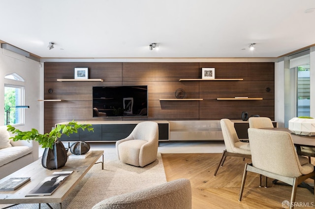 living room featuring light hardwood / wood-style flooring, ornamental molding, and a wealth of natural light