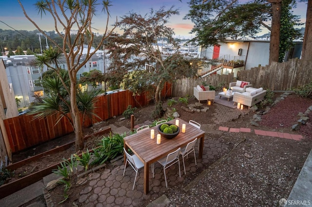 yard at dusk with a fenced backyard, a patio, and an outdoor hangout area