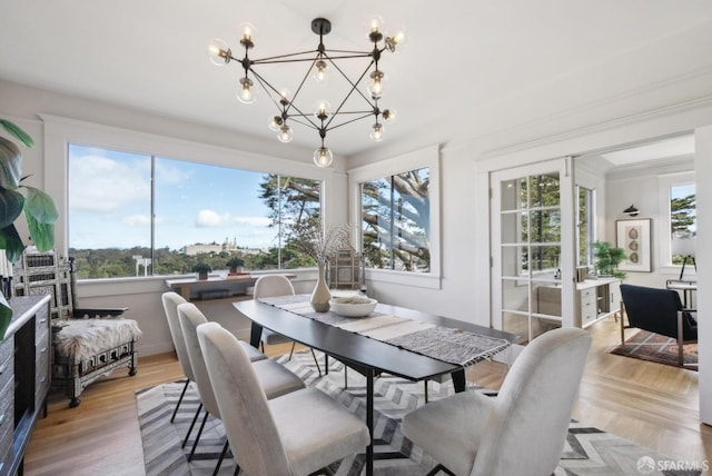 dining room featuring a chandelier, baseboards, and light wood-style floors