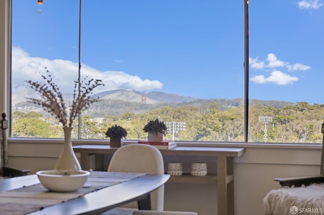 exterior space featuring a forest view, a mountain view, and a wealth of natural light