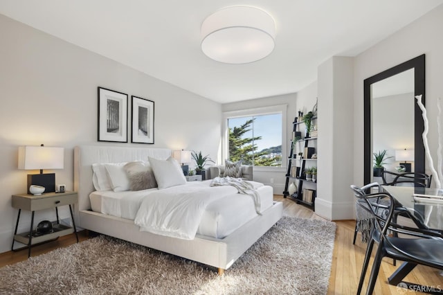 bedroom with light wood finished floors and baseboards