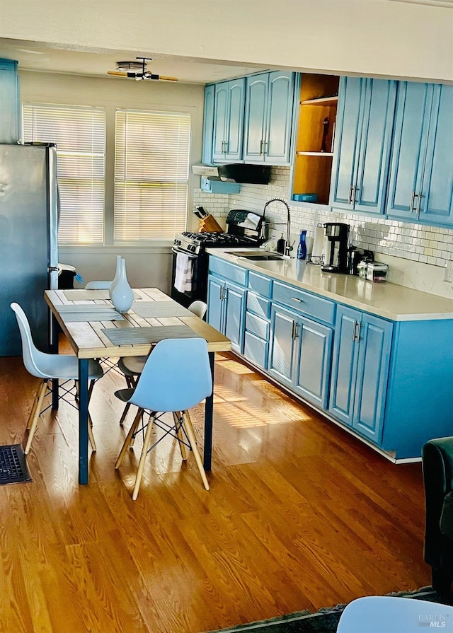 22 NE Selfridge St, Vallejo, CA 94590 - kitchen featuring blue cabinetry, freestanding refrigerator, black gas range oven, and ventilation hood