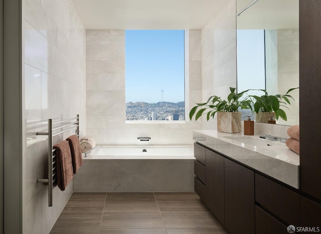 488 Folsom St Unit 5501, San Francisco, CA 94105 - full bathroom featuring vanity, a garden tub, tile walls, and a towel warmer