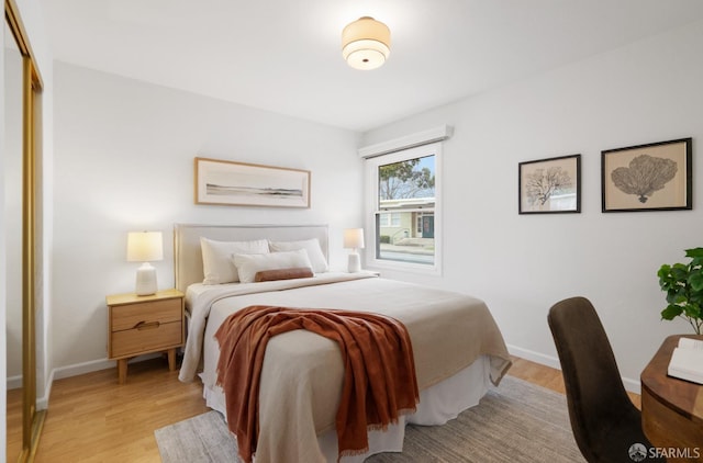 bedroom with light wood-type flooring and baseboards