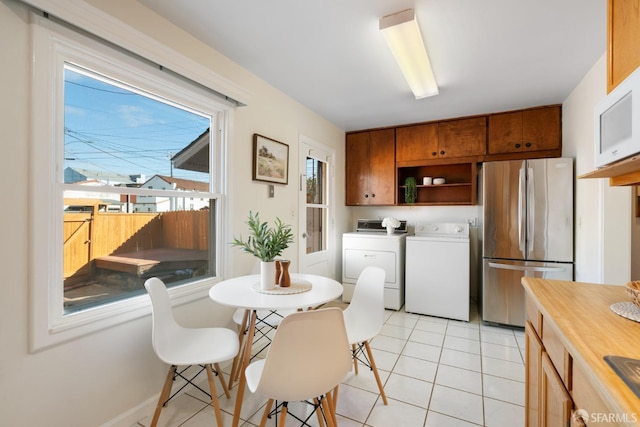 kitchen featuring washer and dryer, freestanding refrigerator, plenty of natural light, and open shelves