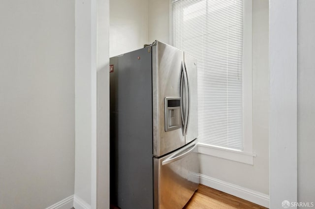 kitchen with hardwood / wood-style flooring and stainless steel refrigerator with ice dispenser