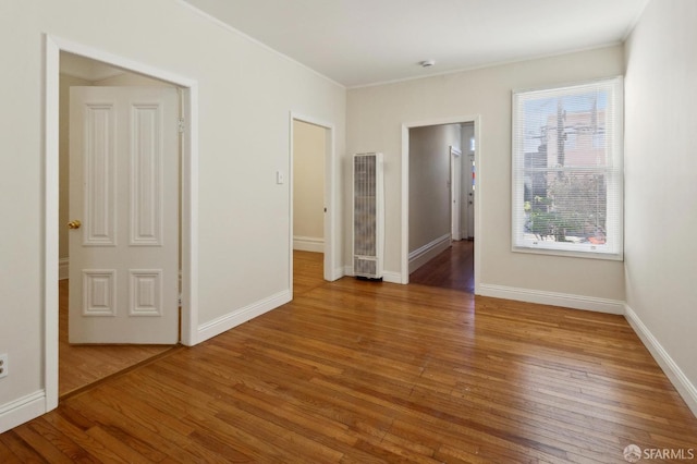 empty room featuring hardwood / wood-style floors and ornamental molding