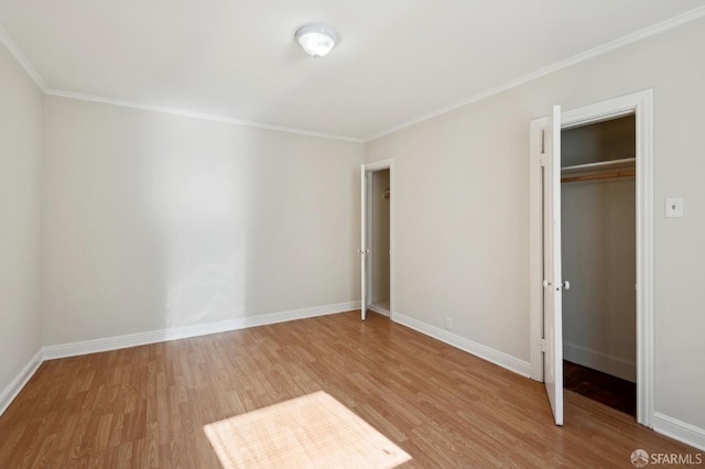 unfurnished bedroom featuring ornamental molding, wood-type flooring, and a closet