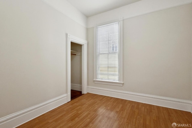 unfurnished bedroom with hardwood / wood-style flooring and a closet