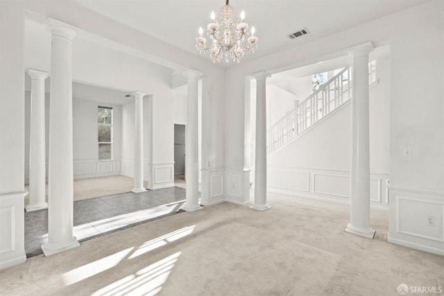 carpeted empty room featuring a wealth of natural light and an inviting chandelier