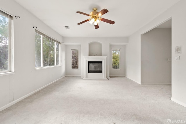 unfurnished living room featuring ceiling fan and light colored carpet