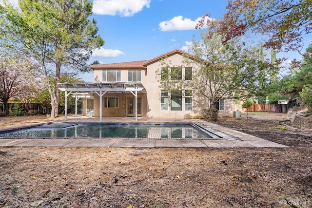 rear view of house featuring a pergola, a patio area, and a fenced in pool