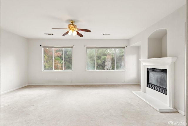 unfurnished living room with light colored carpet and plenty of natural light