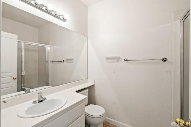 bathroom with vanity, toilet, and a shower with door