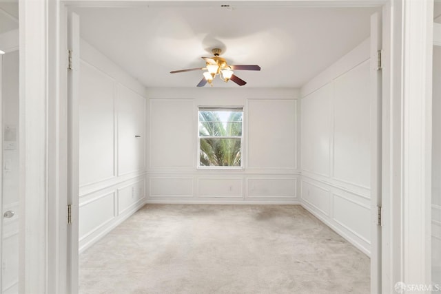 carpeted spare room with ceiling fan