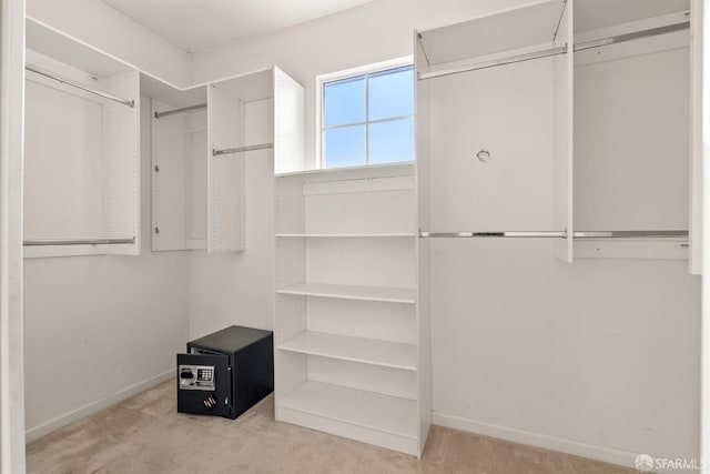 walk in closet featuring light colored carpet