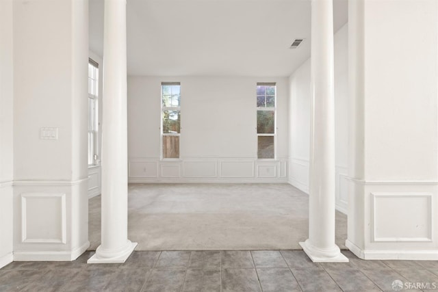 carpeted empty room with ornate columns