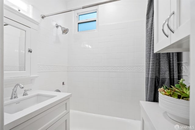 bathroom with tiled shower / bath combo and vanity