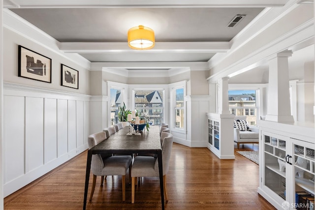 dining area featuring decorative columns, crown molding, and a healthy amount of sunlight