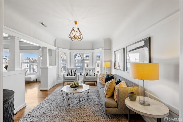 living room with decorative columns and hardwood / wood-style flooring