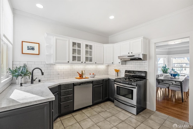 kitchen featuring sink, white cabinetry, light tile patterned floors, light stone countertops, and stainless steel appliances