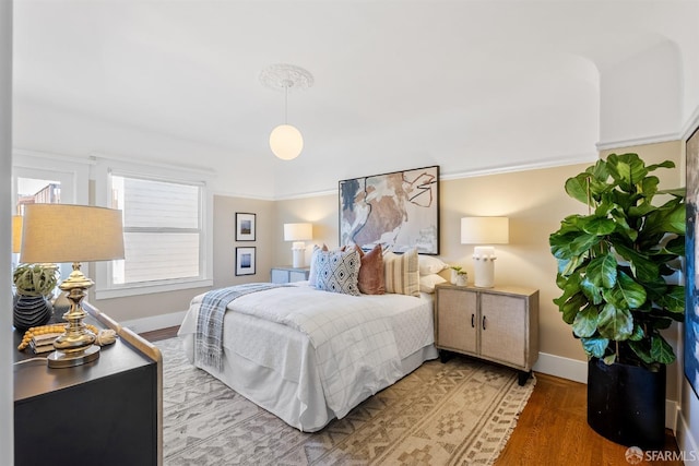 bedroom with crown molding and light hardwood / wood-style floors