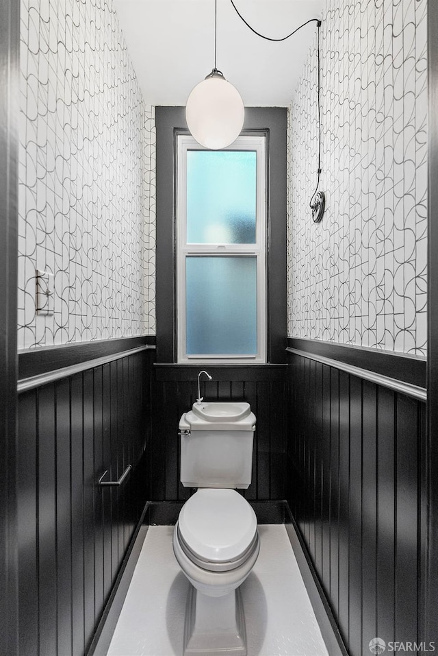 bathroom featuring toilet and wooden walls