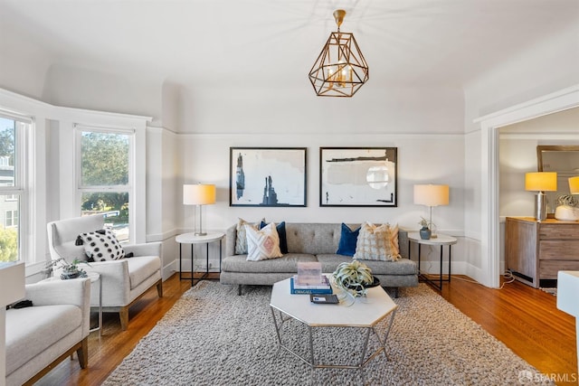 living room with hardwood / wood-style flooring, a chandelier, and plenty of natural light