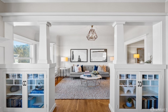 living room featuring ornate columns and wood-type flooring