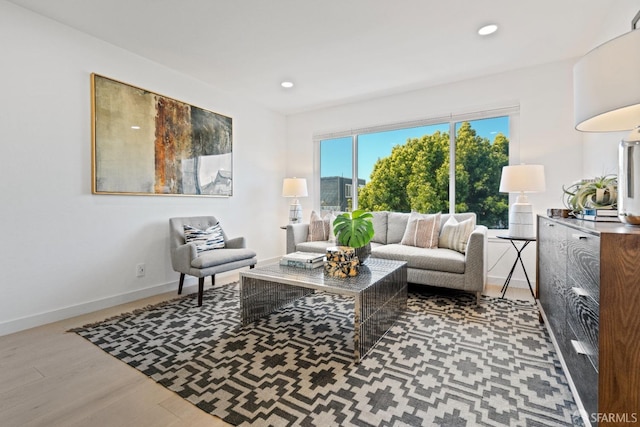 living area featuring baseboards, wood finished floors, and recessed lighting