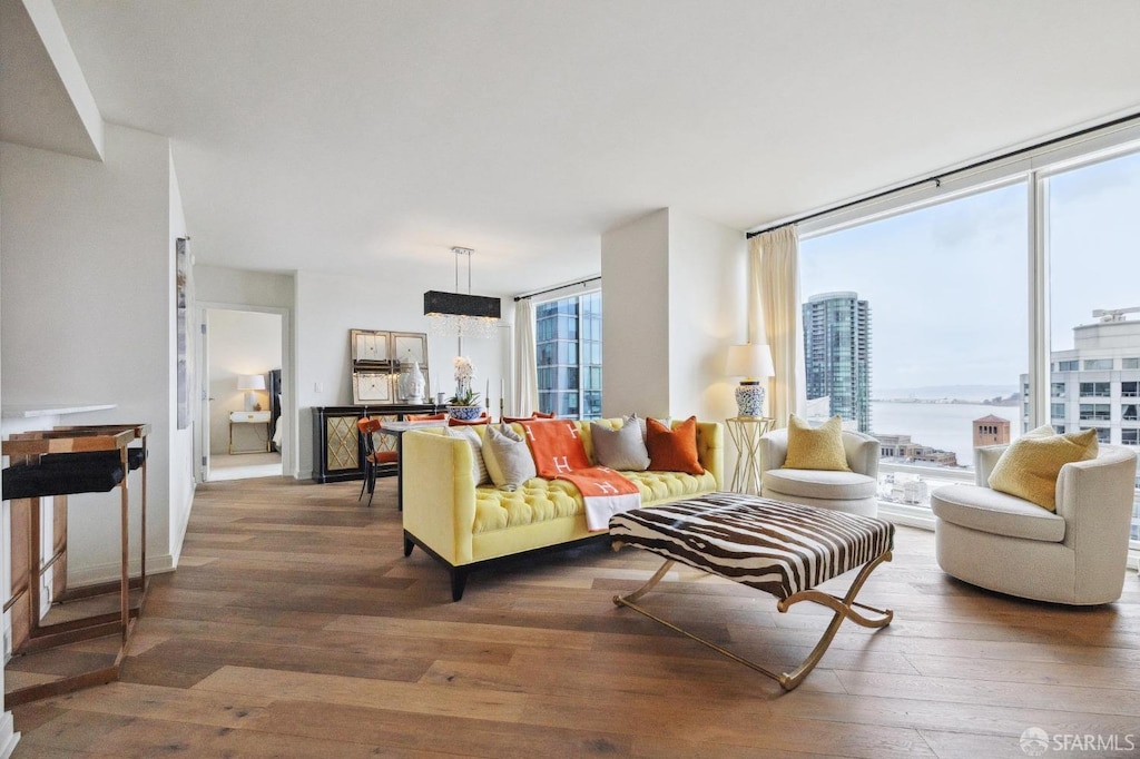 living room featuring floor to ceiling windows, a water view, and hardwood / wood-style floors