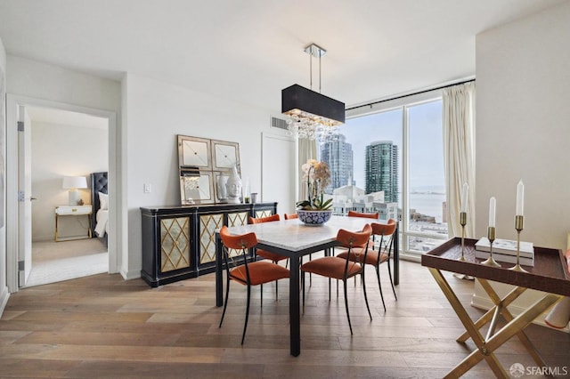 dining area with a chandelier, plenty of natural light, and hardwood / wood-style floors