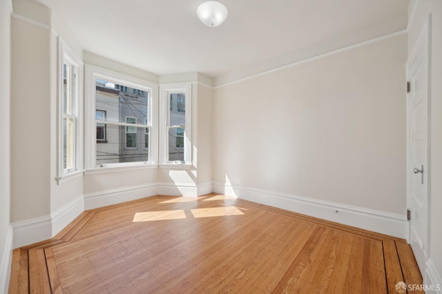 empty room featuring wood finished floors and baseboards